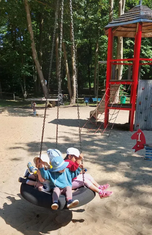 Kinder schaukeln auf dem Spielplatz